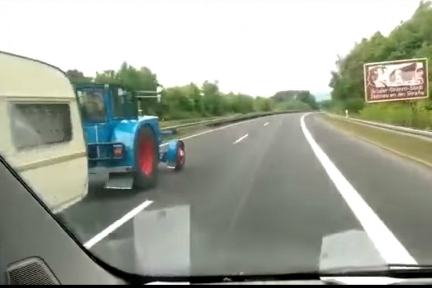 Traktor z przyczepą wyprzedza busa na autostradzie (WIDEO)